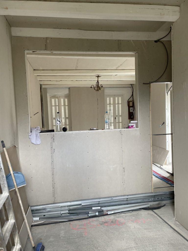 Une pièce en construction avec une porte et une fenêtre en cours d'installation.