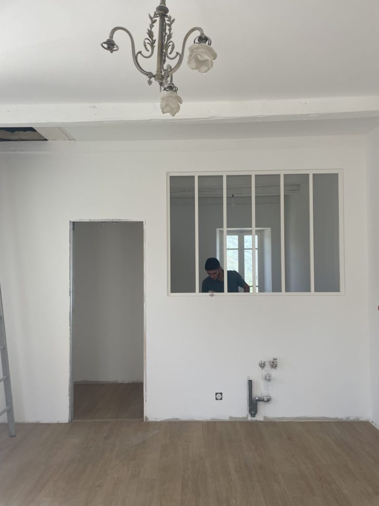 Une pièce en construction avec une porte et une fenêtre en cours d'installation.